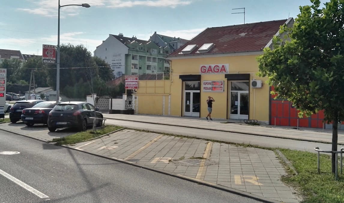 Spoljni ulaz u GAGA menjačnicu na žutoj zgradi pored parkinga.